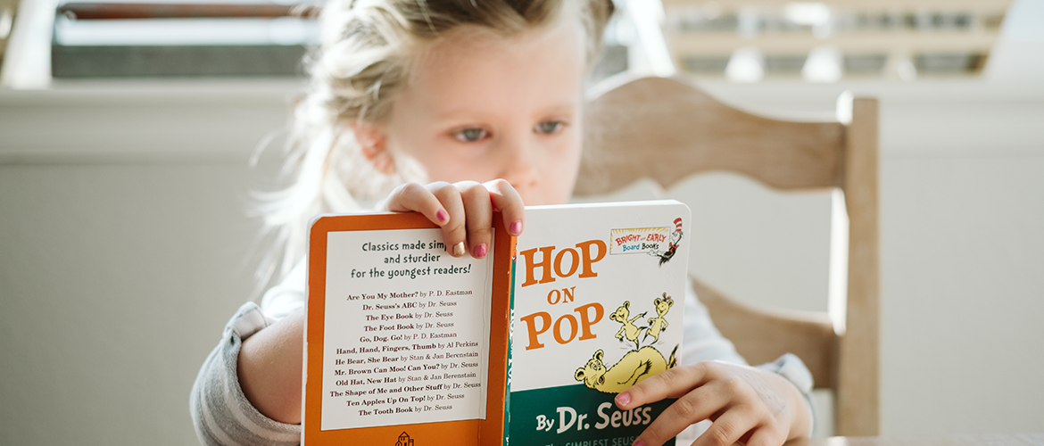 Girl reading "Hop on Pop" by Dr. Seuss