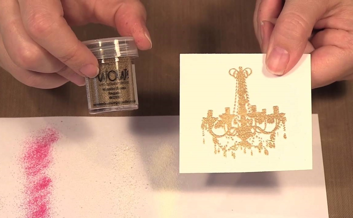 hands holding embossing powder and a hand made card