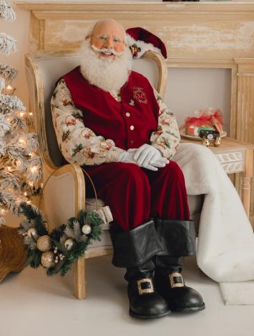 Santa sitting in a chair with milk and cookies